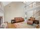 Expansive living area featuring a soaring ceiling, wooden floors, and a view of the staircase at 9 Warrior Way, Sharpsburg, GA 30277