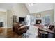 Inviting living room featuring a brick fireplace, hardwood floors and leather furniture at 9 Warrior Way, Sharpsburg, GA 30277