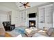 A cozy living room featuring a fireplace, built-in bookshelves, and a vaulted ceiling at 9 Warrior Way, Sharpsburg, GA 30277