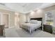 Large main bedroom with carpet floors, a bed with blue pillows, tray ceilings and many windows at 9 Warrior Way, Sharpsburg, GA 30277