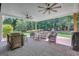 Inviting covered patio with brick flooring, ceiling fans, and outdoor seating area overlooking wooded backyard at 9 Warrior Way, Sharpsburg, GA 30277