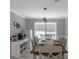 Inviting dining room with modern lighting, long table set for dinner, and view to the coffee bar at 308 Larkspur Turn, Peachtree City, GA 30269