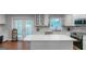 A bright kitchen featuring white cabinets, an island, stainless appliances, and a marble backsplash at 308 Larkspur Turn, Peachtree City, GA 30269