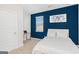 Cozy bedroom with a full bed, blue accent wall, natural light, and a compact workspace at 12167 Conrad Cir, Hampton, GA 30228