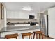 Modern kitchen with stainless steel appliances, granite countertops, and a breakfast bar with wooden stools at 183 Wynnmeade, Peachtree City, GA 30269