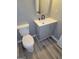 Bathroom showcasing a gray vanity and a white toilet with wood floors at 2587 Mead Ct, Jonesboro, GA 30236