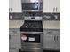 Stainless steel gas range with modern microwave and sleek backsplash at 2587 Mead Ct, Jonesboro, GA 30236