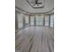 Living room showcases a ceiling fan, large windows, and light-colored wood flooring at 2587 Mead Ct, Jonesboro, GA 30236