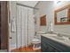 This bathroom boasts a tub/shower with white tile, a dark blue vanity, and wood-look flooring at 53 Born St, Norcross, GA 30071