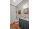 Charming bathroom with a blue vanity, wood floors and a tub shower with a ruffled curtain at 53 Born St, Norcross, GA 30071