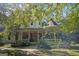 Inviting two-story home featuring a classic wraparound porch with lush landscaping at 53 Born St, Norcross, GA 30071