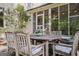 Charming outdoor patio features wood table with chairs and blue cushions, surrounded by lush greenery at 53 Born St, Norcross, GA 30071