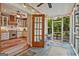 Enclosed sunroom with a screened door, ceiling fan and adjacent kitchen view at 53 Born St, Norcross, GA 30071