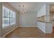Bright dining area with wood-look floors, a chandelier, and easy access to the kitchen, perfect for Gathering meals at 470 Cornwallis Way, Fayetteville, GA 30214