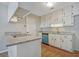 Cozy kitchen featuring granite countertops, white cabinets, and wood flooring at 470 Cornwallis Way, Fayetteville, GA 30214