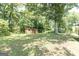 Expansive backyard featuring a storage shed, mature shade tree, and green lawn at 1112 Mealor Rd, Lawrenceville, GA 30043