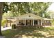 Charming brick home features a covered porch, well-maintained lawn, and mature trees at 1112 Mealor Rd, Lawrenceville, GA 30043