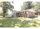 Single-story brick home with well-kept lawn, mature trees, and an inviting front entrance at 1112 Mealor Rd, Lawrenceville, GA 30043