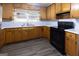 Bright kitchen features wood cabinets, black appliances, light countertops, and a window over the sink at 1112 Mealor Rd, Lawrenceville, GA 30043
