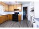 Cozy kitchen features wood cabinets, black appliances, vinyl floor and white countertops at 1112 Mealor Rd, Lawrenceville, GA 30043