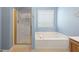 Bathroom features a tub-shower combination, vanity with white countertop, and a window for natural light at 377 Avian Forest Dr, Stockbridge, GA 30281