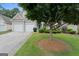Charming home featuring a two-car garage and an inviting front yard with mature landscaping at 377 Avian Forest Dr, Stockbridge, GA 30281