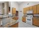 A kitchen featuring granite countertops, oak cabinets, and a white stove and microwave at 377 Avian Forest Dr, Stockbridge, GA 30281