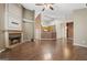 A living room showcasing wood floors, a fireplace, and an open layout leading into the kitchen at 377 Avian Forest Dr, Stockbridge, GA 30281