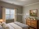 This bedroom has neutral walls, a window with blinds, a dresser with decor and is staged with a comfortable bed at 51 Estates Dr, Villa Rica, GA 30180