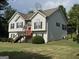 Charming home with a vibrant red door, manicured lawn and stone accents. Side view showing deck at 51 Estates Dr, Villa Rica, GA 30180