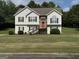 Inviting two-story home with a well-manicured lawn, red front door, and decorative stone accents at 51 Estates Dr, Villa Rica, GA 30180