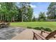 Spacious backyard with a concrete patio featuring outdoor seating, a lush lawn, and mature trees at 200 Pine Tree Ln, Mcdonough, GA 30252