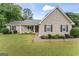 Inviting single-story home featuring a lush green lawn, rocking chairs, and manicured landscaping at 200 Pine Tree Ln, Mcdonough, GA 30252