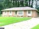 Charming brick home with a well-maintained lawn, complemented by a light green front door and traditional shuttered windows at 10178 Top Tree Ct, Jonesboro, GA 30238