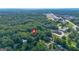 Aerial view of a wooded neighborhood with the home pinpointed amongst lush greenery and surrounding amenities at 357 W Hightower Trl, Social Circle, GA 30025