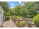 Inviting outdoor space featuring a wood deck overlooking a lush, green backyard and beautiful mature trees at 357 W Hightower Trl, Social Circle, GA 30025