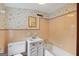 Charming bathroom featuring patterned wallpaper, pink tiling, and vintage fixtures at 357 W Hightower Trl, Social Circle, GA 30025