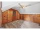 An attic bedroom with wood paneling and carpeted floors, has a ceiling fan and cozy feel at 357 W Hightower Trl, Social Circle, GA 30025