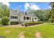 Charming home featuring a manicured lawn, black trimmed windows, and a black metal fence at 357 W Hightower Trl, Social Circle, GA 30025