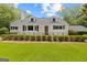 Charming home featuring a manicured lawn, black trimmed windows, and a black metal fence at 357 W Hightower Trl, Social Circle, GA 30025