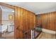 The upstairs hallway leads to a bathroom, and has wood-paneled walls with carpet floors at 357 W Hightower Trl, Social Circle, GA 30025