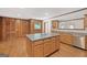 View of kitchen with wood paneled walls, light wood cabinetry and island at 357 W Hightower Trl, Social Circle, GA 30025