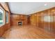 Spacious living room with hardwood floors, a brick fireplace, and wood-paneled walls at 357 W Hightower Trl, Social Circle, GA 30025