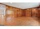 Expansive living room featuring wood-paneled walls, hardwood floors, and access to other rooms at 357 W Hightower Trl, Social Circle, GA 30025