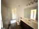 Clean bathroom with a shower-tub combo and a dark wood vanity at 1650 Larkspur Trl, Conyers, GA 30012