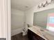 Bathroom with a shower-tub combination and single sink vanity with a large mirror at 1650 Larkspur Trl, Conyers, GA 30012