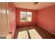 Bedroom with pink walls, neutral carpet, and a window overlooking the yard at 1650 Larkspur Trl, Conyers, GA 30012