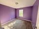 Bedroom with purple walls, carpet flooring, a white window, and base trim at 1650 Larkspur Trl, Conyers, GA 30012