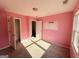 Bedroom featuring pink walls, light-colored carpet, neutral trim, and a closet at 1650 Larkspur Trl, Conyers, GA 30012