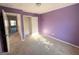 Bedroom featuring light-colored carpet, neutral trim, purple walls, and a closet at 1650 Larkspur Trl, Conyers, GA 30012
